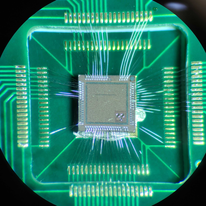 a picture of the Bloomsbury chip down a microscope showing it with wire bonds to a PCB (as tested)